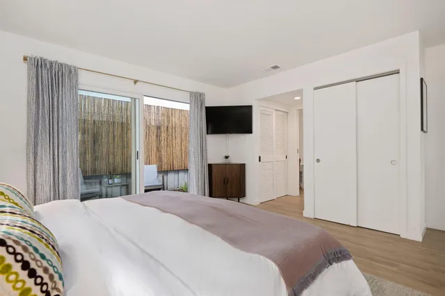 a bedroom with a bed and a flat screen tv