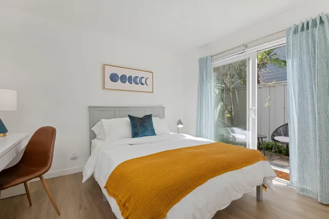 a bed sitting in a bedroom next to a window