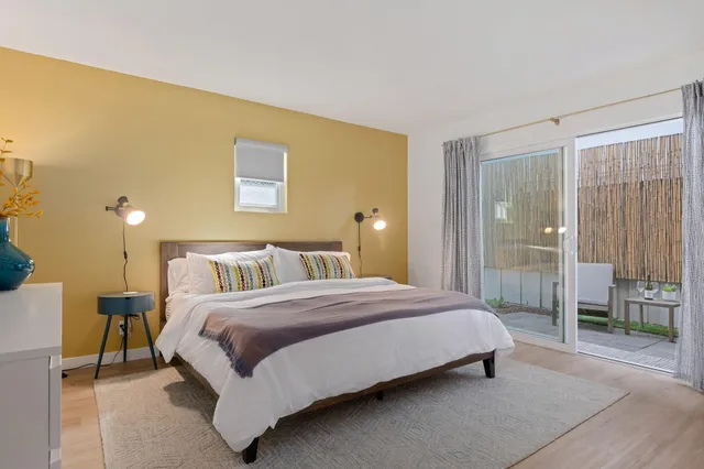 a bedroom with a bed lamp and a large window