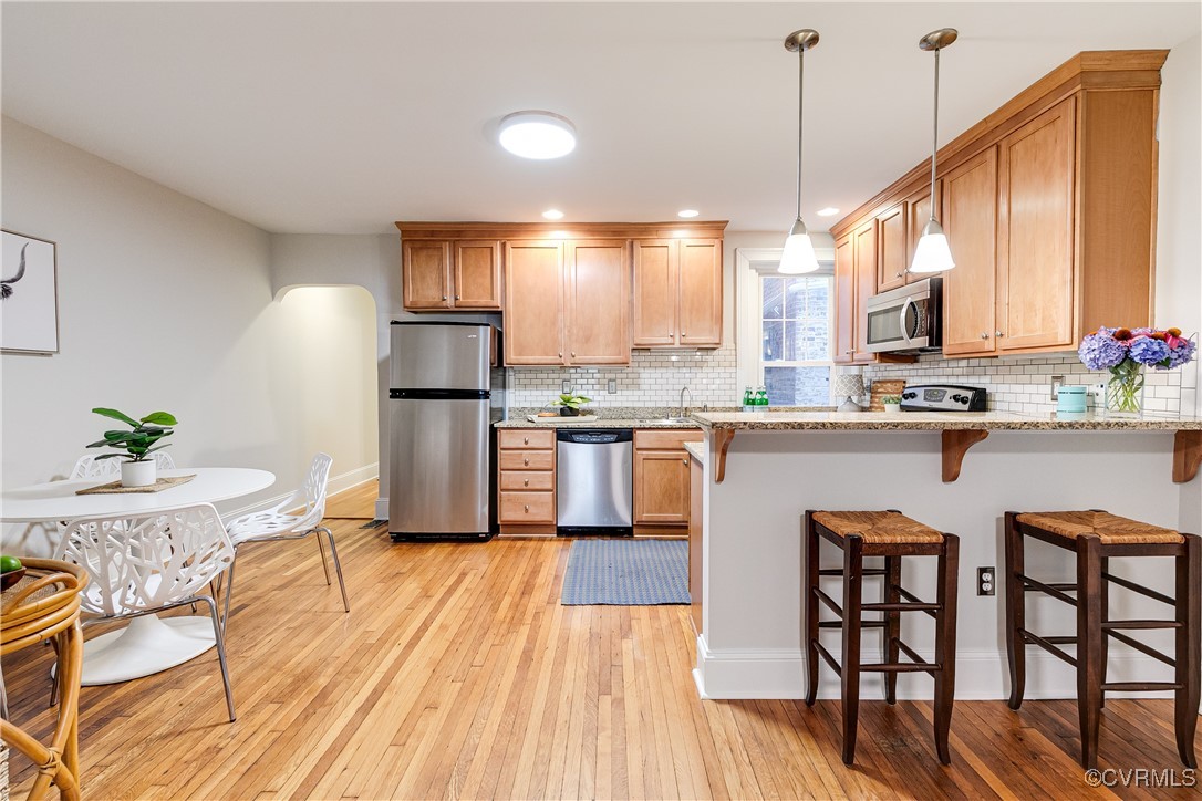 619 Roseneath Road, Unit U21 Richmond, VA 23221 - Photo 8 of 21 a kitchen with stainless steel appliances granite countertop a stove top oven a sink dishwasher a dining table and chairs with wooden floor