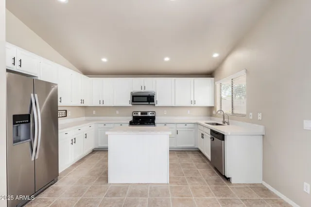 a kitchen with white cabinets stainless steel appliances and sink