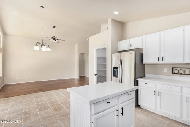 a kitchen with white cabinets and refrigerator