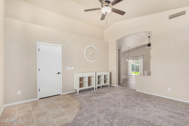 a view of a livingroom with a chandelier fan and windows
