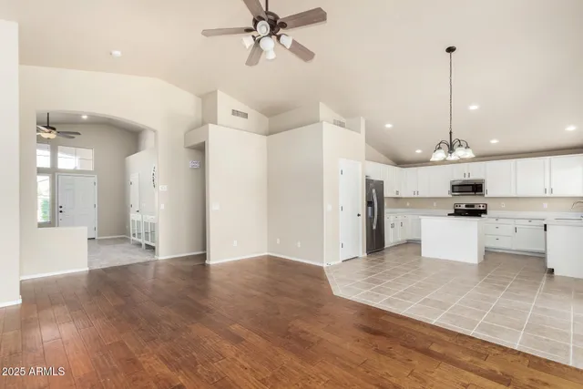 a view of an empty room and kitchen view