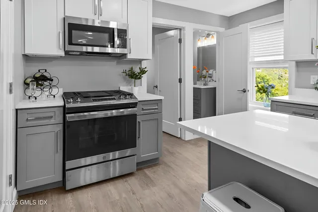 a kitchen with stainless steel appliances a stove a microwave and cabinets