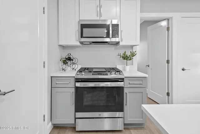a kitchen with stainless steel appliances granite countertop a stove and a microwave