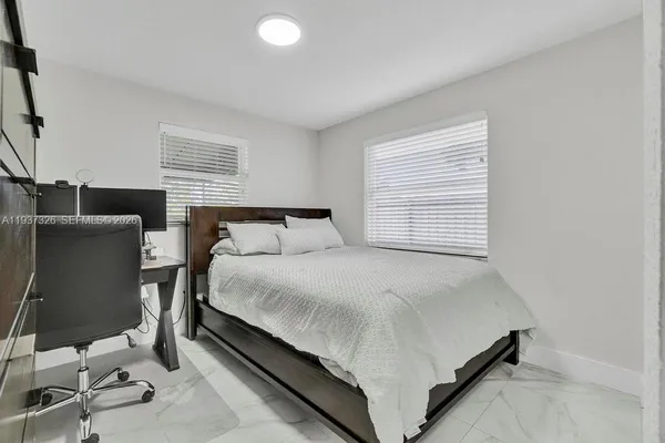 a bed sitting in a bedroom next to a window