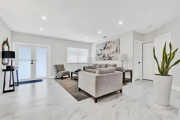 a living room with furniture a window and a flat screen tv