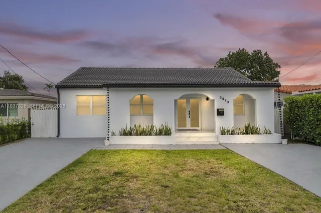 a front view of house with yard and a garden