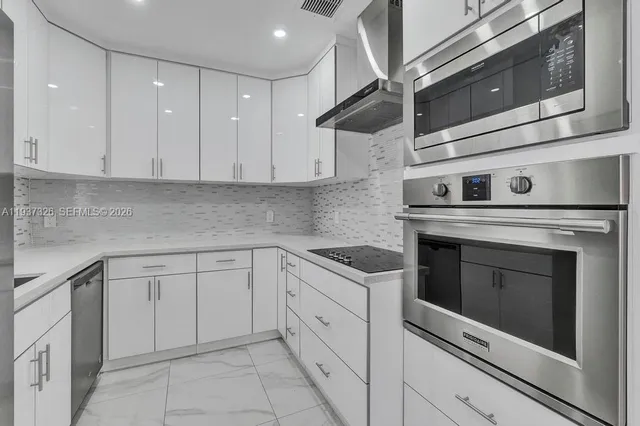 a kitchen with white cabinets stainless steel appliances and sink