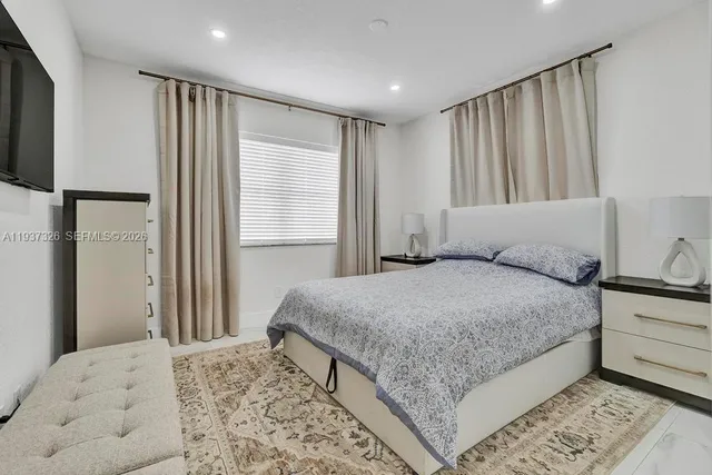 a bedroom with a large bed and a dresser