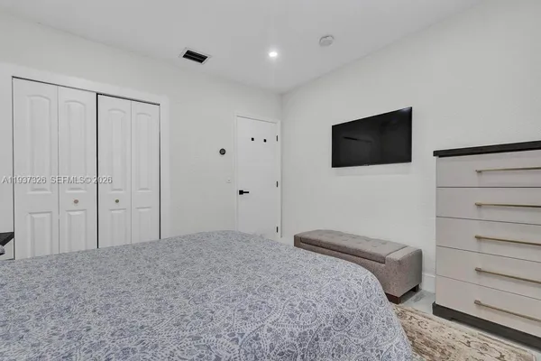 a bedroom with a bed and a flat screen tv