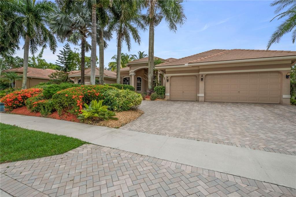 2473 Provence Circle Weston, FL 33327 - Photo 3 of 46 a front view of a house with a garden and a yard