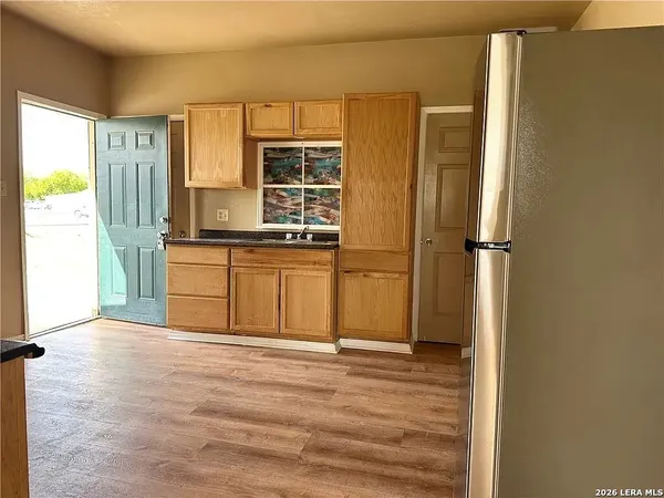 a view of a kitchen with wooden floor and a sink