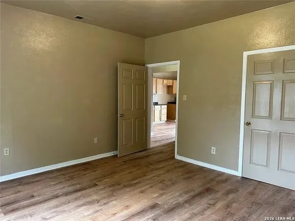 an empty room with wooden floor and closet
