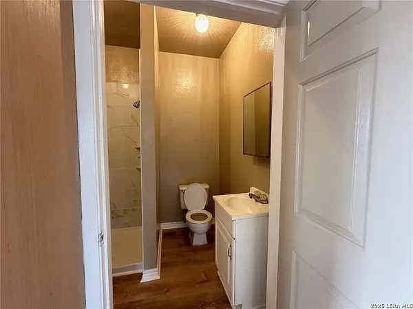 a bathroom with a granite countertop toilet and a shower