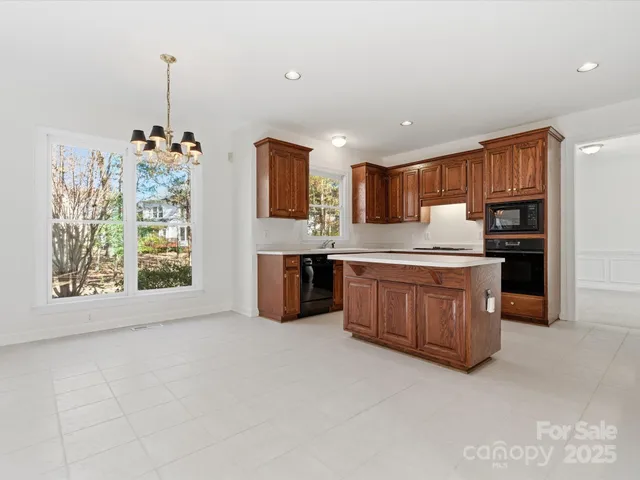 a kitchen with stainless steel appliances kitchen island granite countertop a stove a sink and a refrigerator