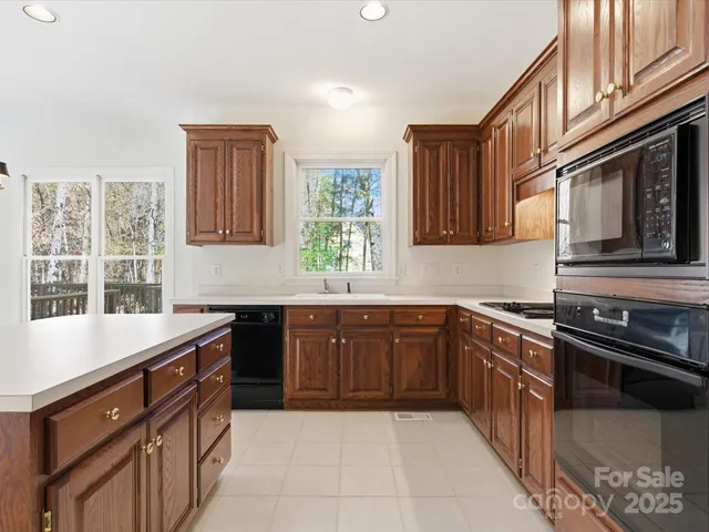 a kitchen with stainless steel appliances granite countertop a sink stove and cabinets