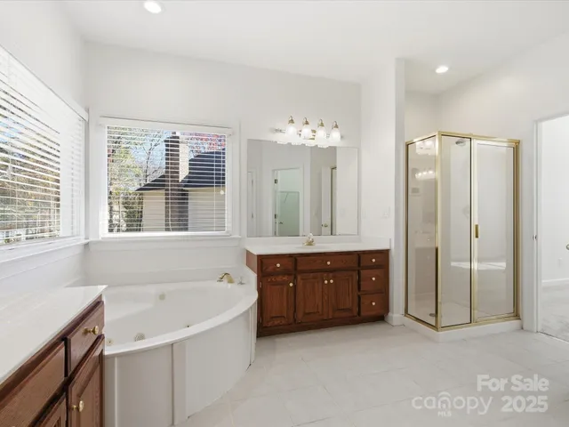 a spacious bathroom with a tub sink shower and mirror