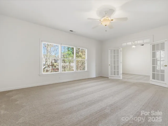 an empty room with fan and windows