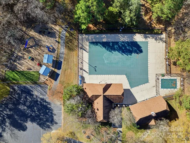 an aerial view of a house with swimming pool and outdoor seating
