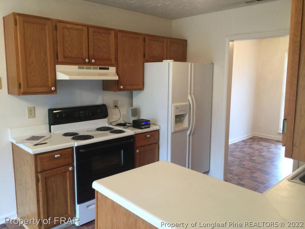 7685 Elliott Bridge Road Spring Lake, NC 28390 - Photo 6 of 26 a kitchen with a stove a refrigerator and a sink
