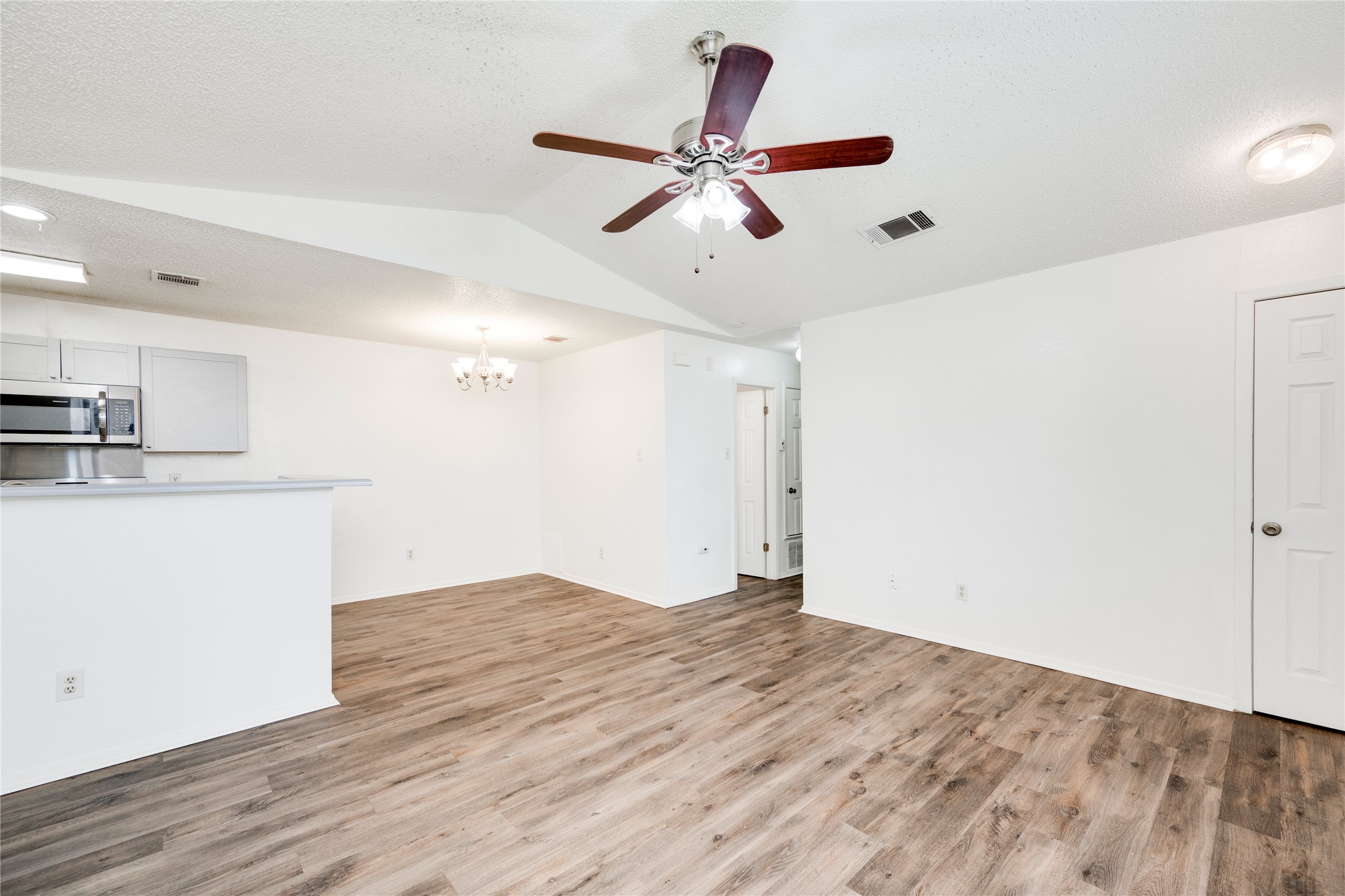 7918 West Gate Boulevard Austin, TX 78745 - Photo 31 of 31 An open floorplan living area featuring wood-look flooring and a ceiling fan.