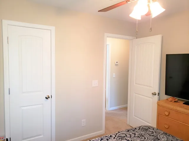 a room with a window and a chandelier fan