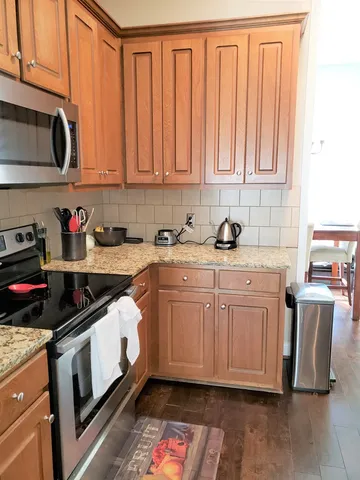 a kitchen with stainless steel appliances granite countertop a sink stove and microwave