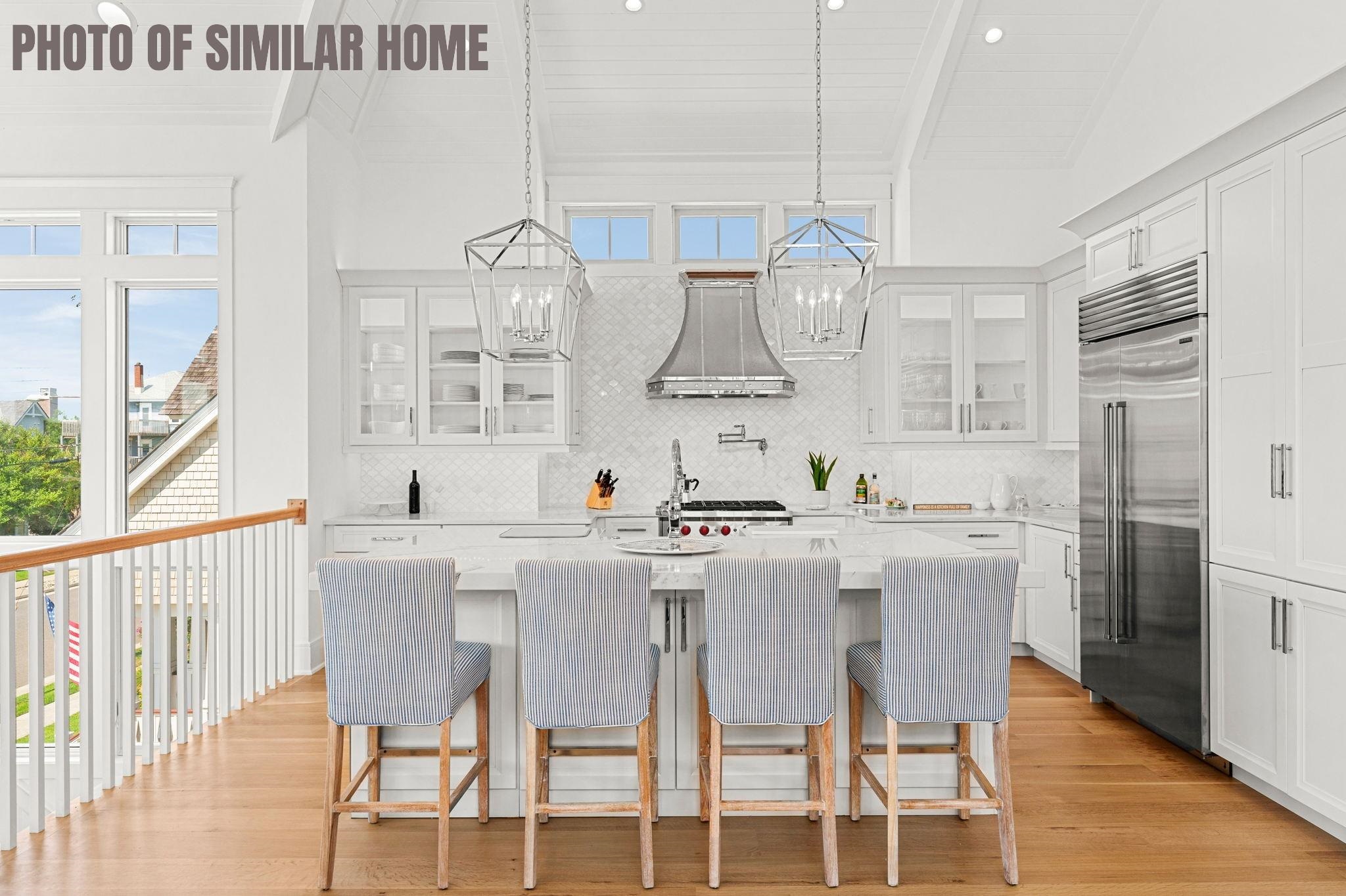 154 98th Street Stone Harbor, NJ 08247 - Photo 30 of 50 a kitchen with stainless steel appliances a dining table chairs and a wooden floor
