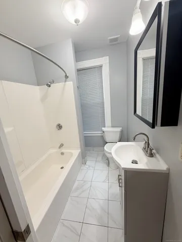 a bathroom with a bathtub a sink and a mirror
