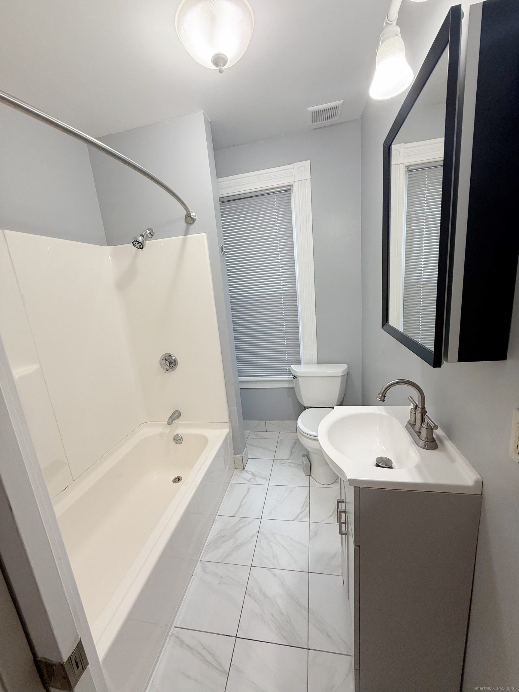 1716 Farmington Avenue Farmington, CT 06085 - Photo 16 of 17 a bathroom with a bathtub a sink and a mirror