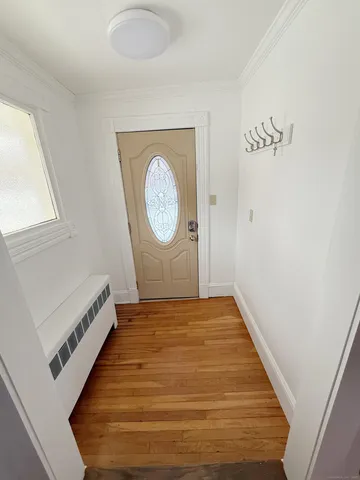 a view of a hallway with wooden floor and a large window