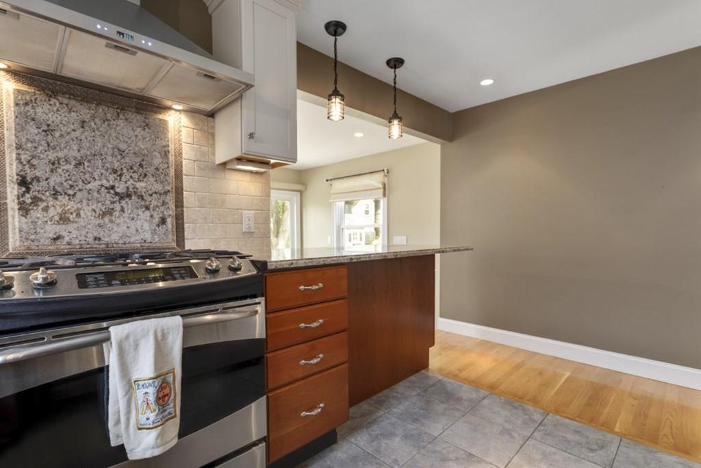 22 Irving Street Reading, MA 01867 - Photo 12 of 37 a kitchen with a stove and a wooden cabinets