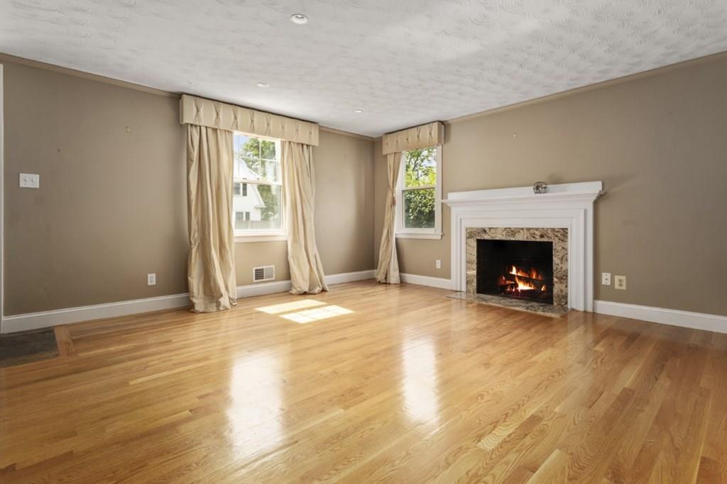 22 Irving Street Reading, MA 01867 - Photo 6 of 37 a view of empty room with wooden floor and fireplace