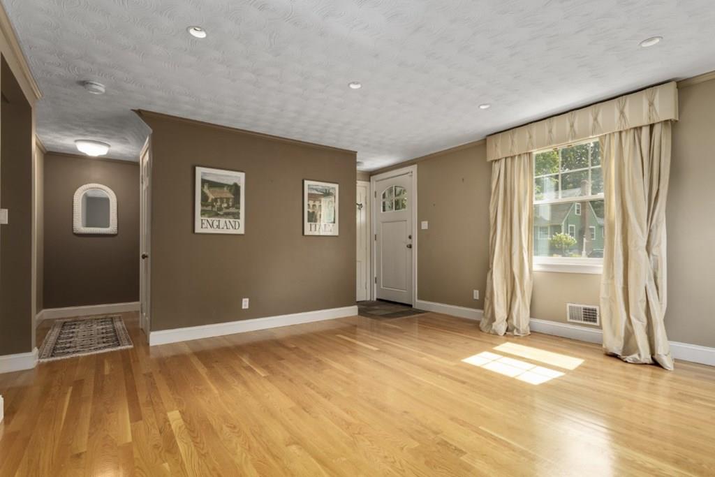 22 Irving Street Reading, MA 01867 - Photo 7 of 37 a view of an empty room with wooden floor and a window