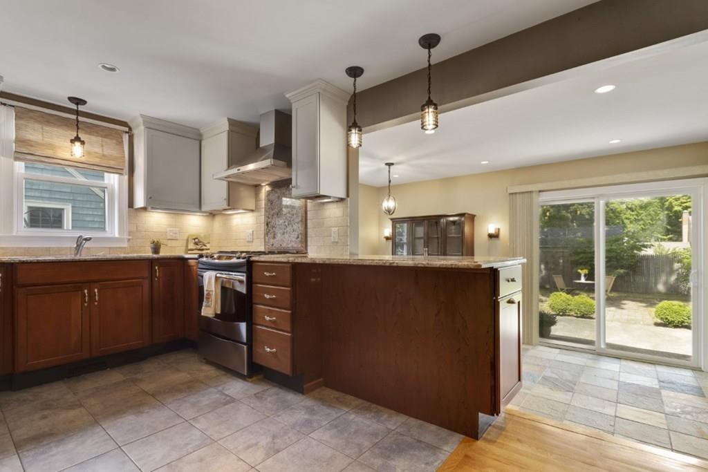 22 Irving Street Reading, MA 01867 - Photo 8 of 37 a kitchen with stainless steel appliances granite countertop a refrigerator a sink dishwasher a stove and a microwave oven with cabinets