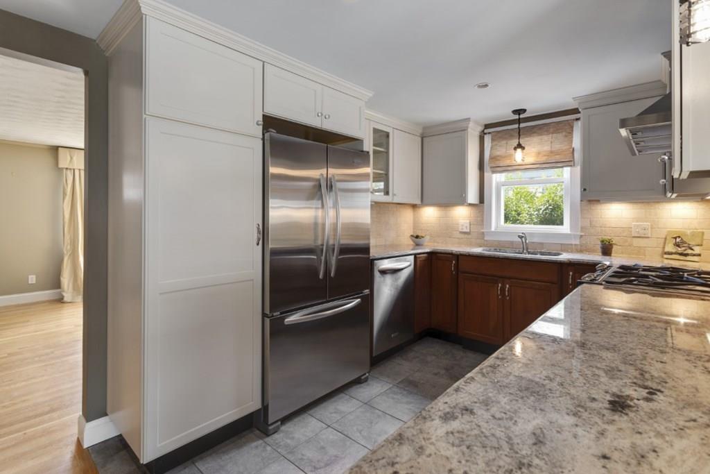 22 Irving Street Reading, MA 01867 - Photo 9 of 37 a kitchen with stainless steel appliances granite countertop a refrigerator a sink a stove and island