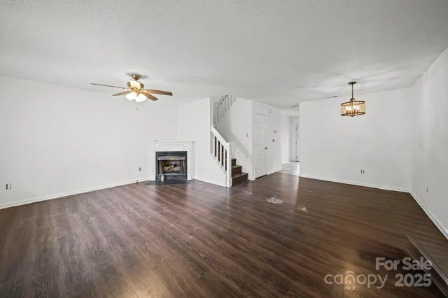 an empty room with wooden floor and staircase