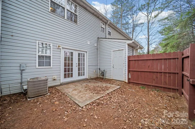 a view of a house with a backyard and wooden fence