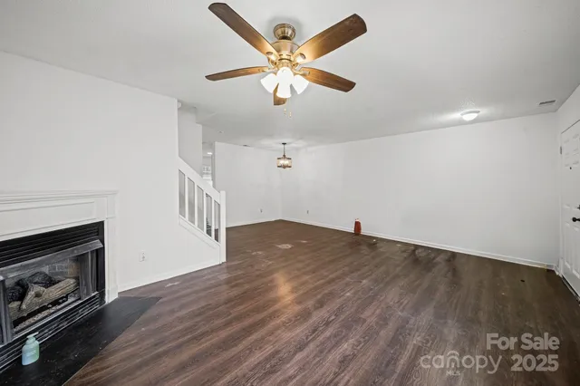 an empty room with wooden floor a ceiling fan and a ceiling fan