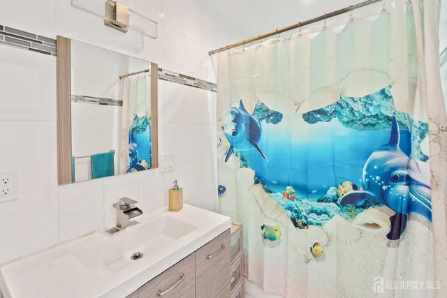 a bathroom with a sink a mirror and a shower curtain