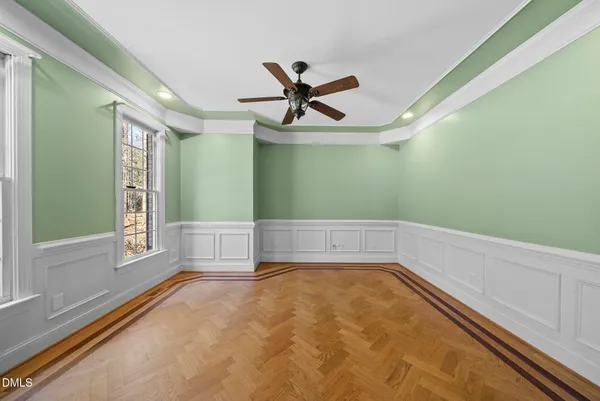 a view of an empty room with wooden floor fireplace and a window