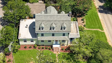 an aerial view of a house with swimming pool and garden