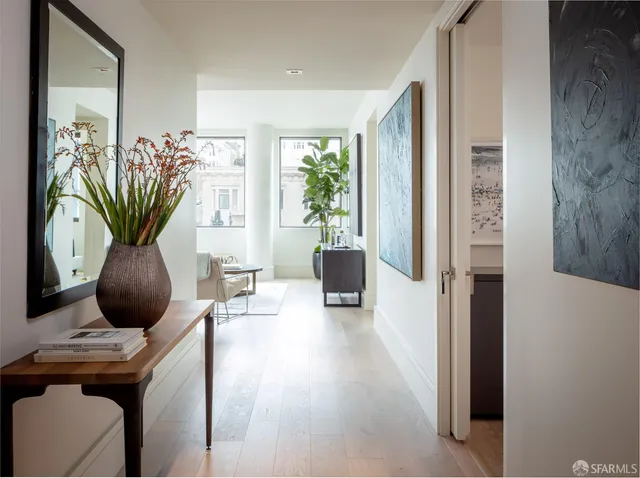 a living room with furniture a potted plant and a large window
