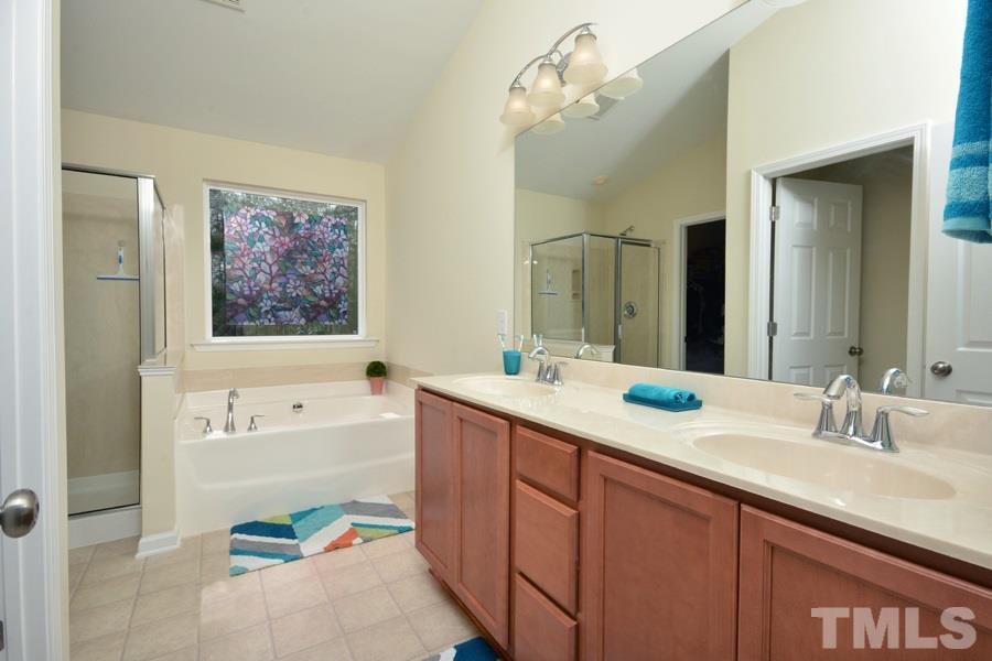 1007 Lakeview Road Durham, NC 27712 - Photo 16 of 25 a bathroom with a sink a large mirror and a bathtub