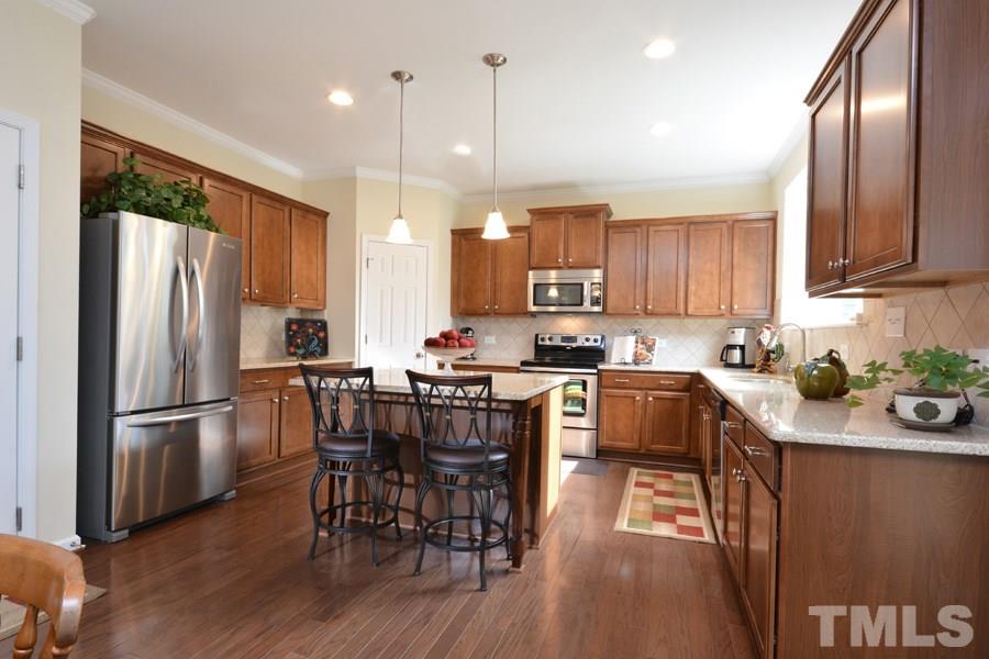 1007 Lakeview Road Durham, NC 27712 - Photo 8 of 25 a kitchen with stainless steel appliances granite countertop a refrigerator a stove a sink a dining table and chairs with wooden floor