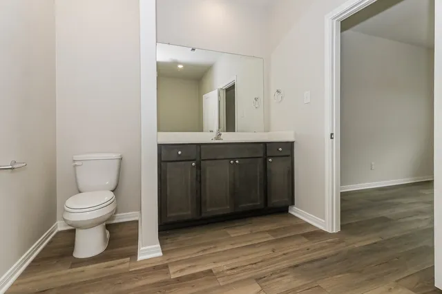 a spacious bathroom with a toilet sink and mirror