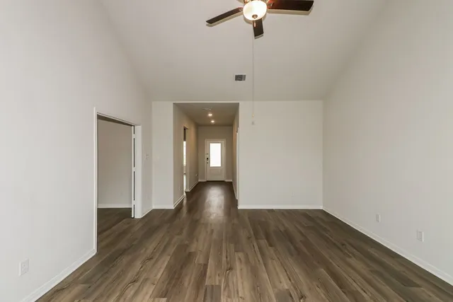 a view of empty room with wooden floor