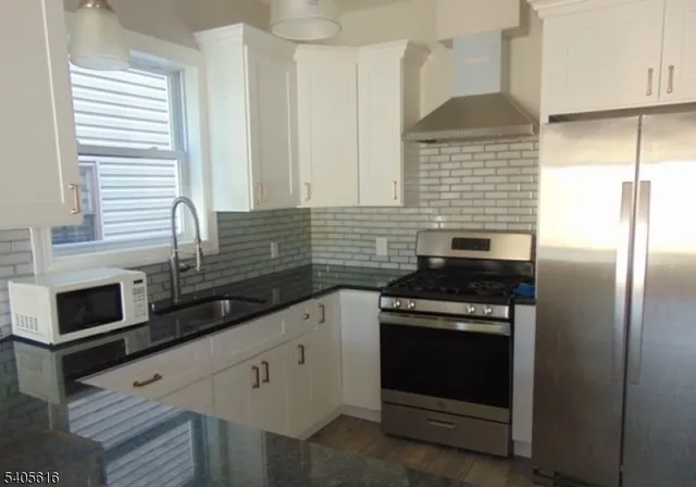 a kitchen with granite countertop cabinets stainless steel appliances and a window